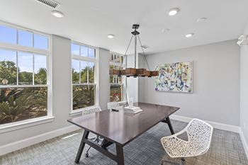 A dining room with a table and chairs and windows